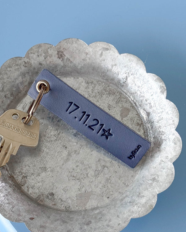 SOLO Small Schlüsselanhänger aus dunkelblauem Leder mit persönlicher Gravur "17.11.21" und Stern, mit Schlüssel in Zinkschale