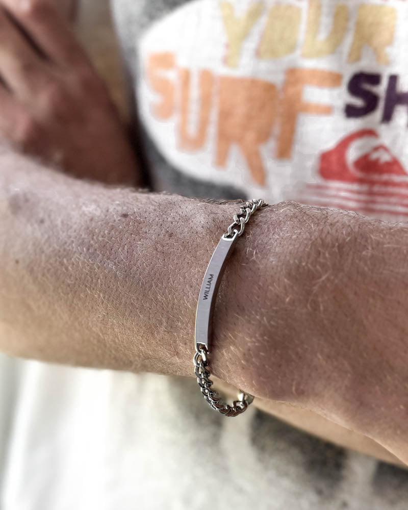ARA Namensarmband aus silberfarbenem Edelstahl mit dem Namen "William" graviert, am Handgelenk am Strand getragen