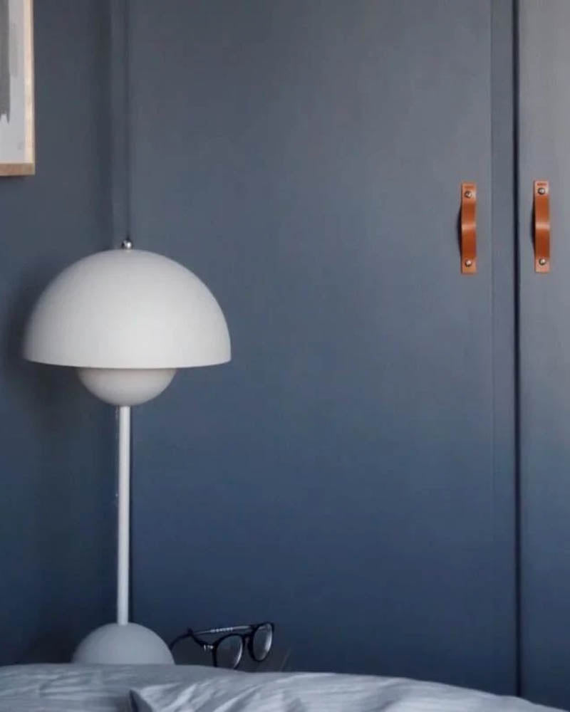 BAND Ledergriffe in Cognac an zwei dunkelblauen Schranktüren im Schlafzimmer mit weißer Flowerpot-Lampe