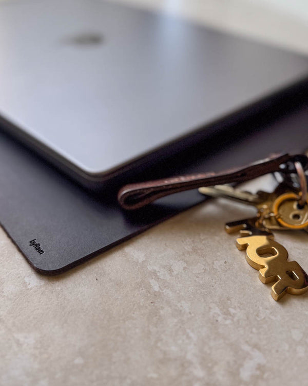 XXL DESK Schreibtischunterlage aus dunkelbraunem Leder unter Laptop mit Schlüsselanhänger aus Leder und goldfarbenem Anhänger