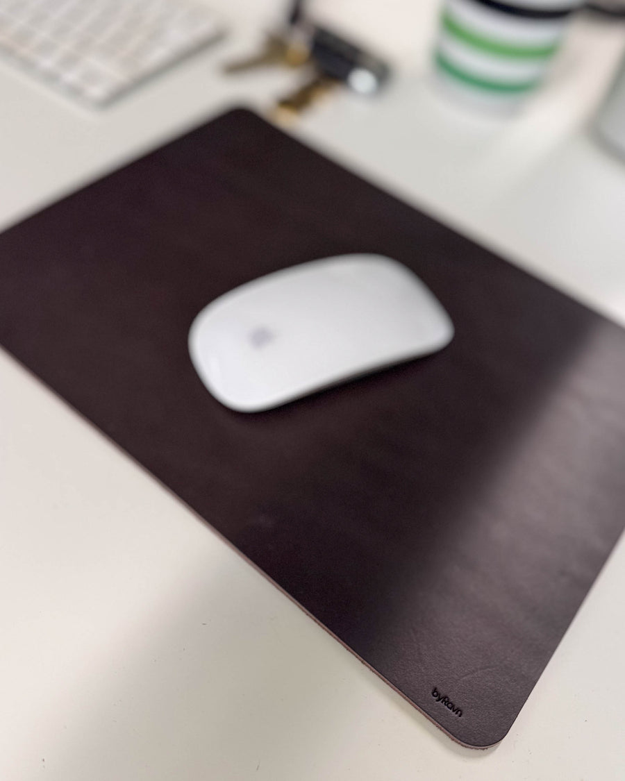 DOS Mauspad aus dunkelbraunem Leder mit weißer Maus auf Schreibtisch mit Tastatur und Schlüsseln