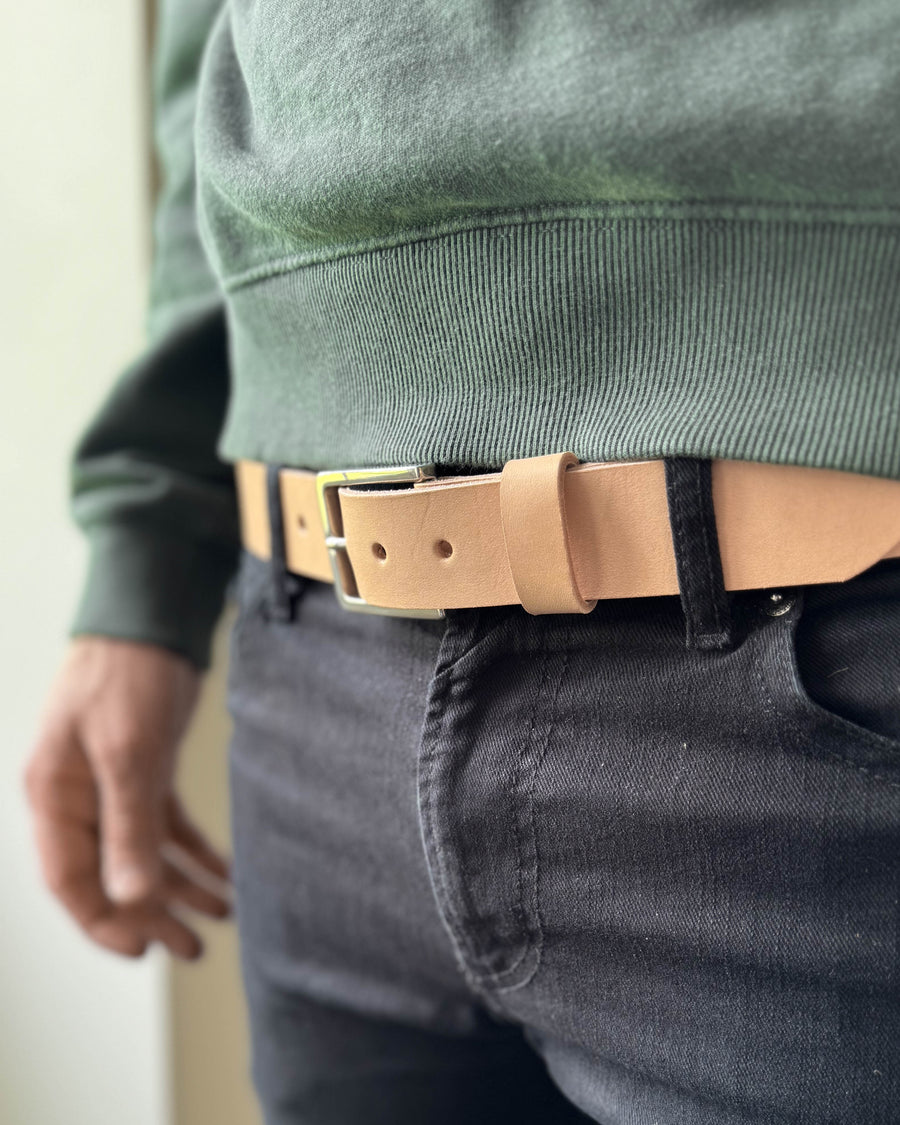 EDGE Gürtel aus naturfarbenem Leder, getragen zu dunkler Jeans mit grünem Sweatshirt