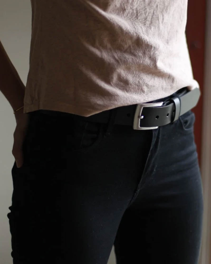 EDGE Gürtel aus schwarzem Leder, getragen von Frau in schwarzer Hose und beigem T-Shirt, Seitenansicht