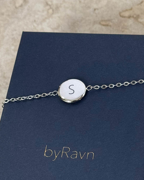 IBI LETTER Armband aus silberfarbenem Edelstahl mit graviertem Buchstaben "S", auf dunkelblauer byRavn Schmuckschachtel