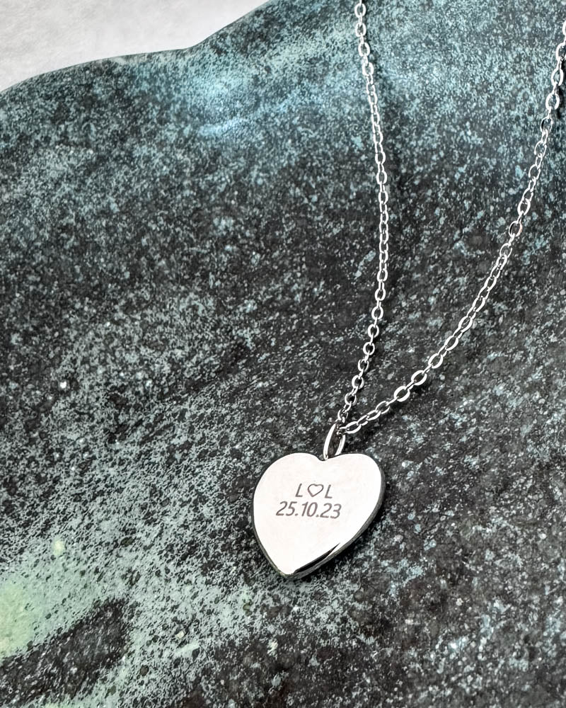LUV QUOTE Halskette aus silberfarbenem Edelstahl mit persönlicher Gravur "L ♡ L 25.10.23" auf Herzanhänger, auf grün patiniertem Stein