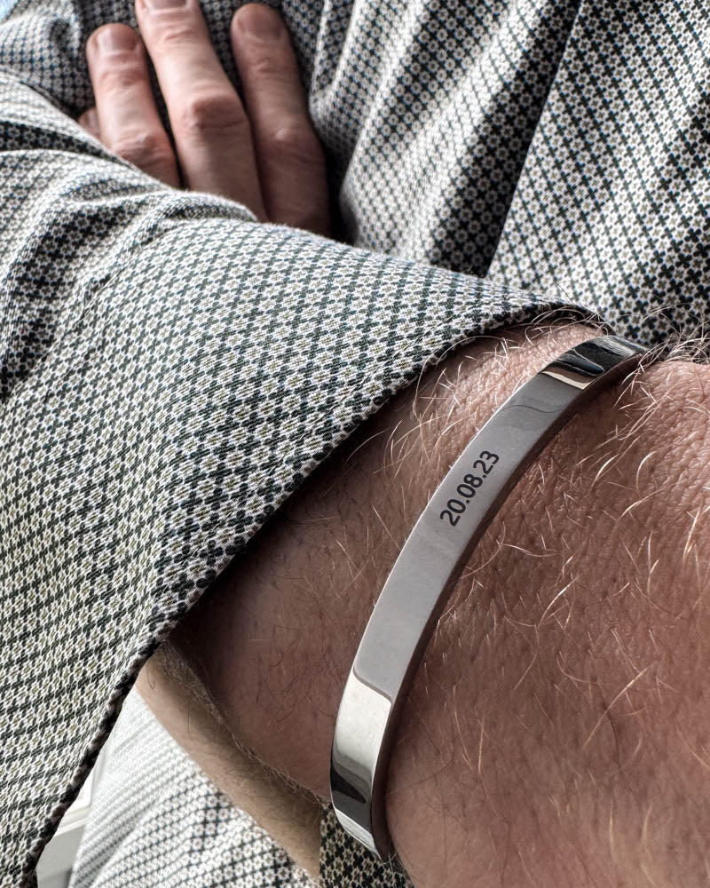 MARS Armband aus silberfarbenem Edelstahl mit graviertem Datum "20.08.23", getragen zu gemustertem Hemd