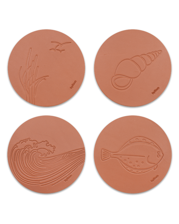 MOKKA Sommerhaus-Untersetzer von byRavn aus cognacfarbenem Leder, Set mit 4 Motiven: Strandhafer mit Möwen, Muschel, Welle und Plattfisch
