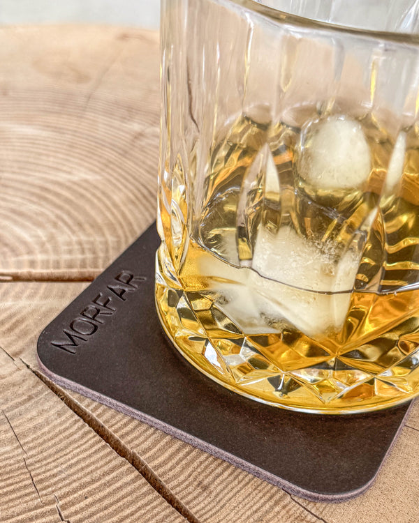 MOKKA quadratischer Untersetzer aus dunkelbraunem Leder mit der Gravur "Morfar" unter Kristallglas mit Whisky und Eis