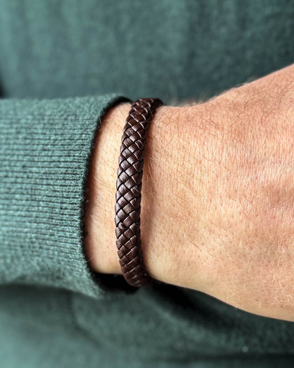 RAY Lederarmband aus dunkelbraunem geflochtenem Leder am Handgelenk eines Mannes, dunkelgrüner Strick
