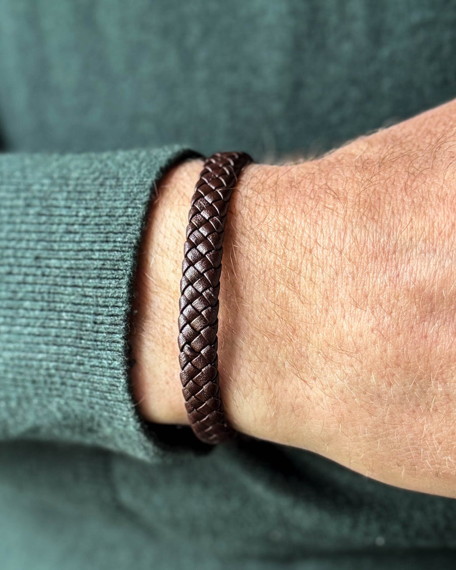 RAY Lederarmband aus dunkelbraunem geflochtenem Leder am Handgelenk eines Mannes, dunkelgrüner Strick