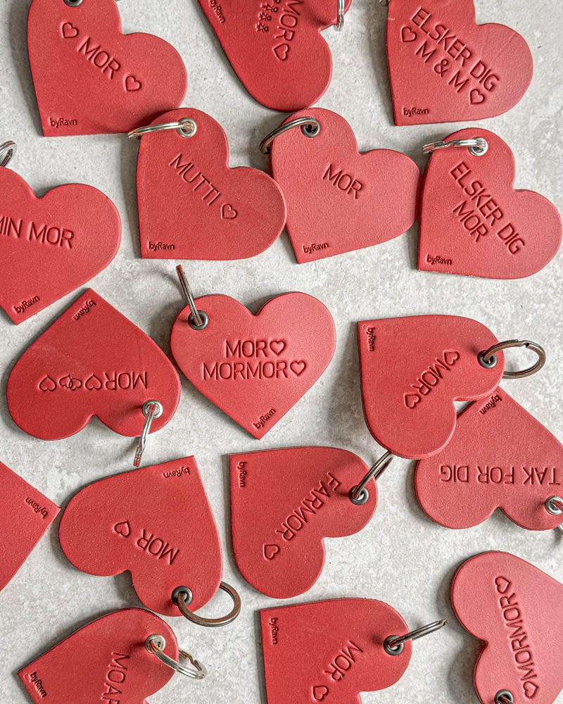 Rote ROSE Herz-Schlüsselanhänger aus Leder von oben mit Gravuren wie "Elsker dig ♡ M & M ♡", "Min mor" und "Farmor" ♡