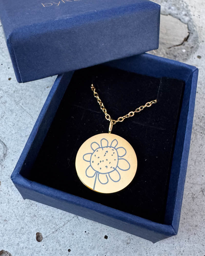 SIA MOTIF Halskette aus vergoldetem Edelstahl mit gravierter Kinderzeichnung einer Blume, in dunkelblauer byRavn Geschenkbox