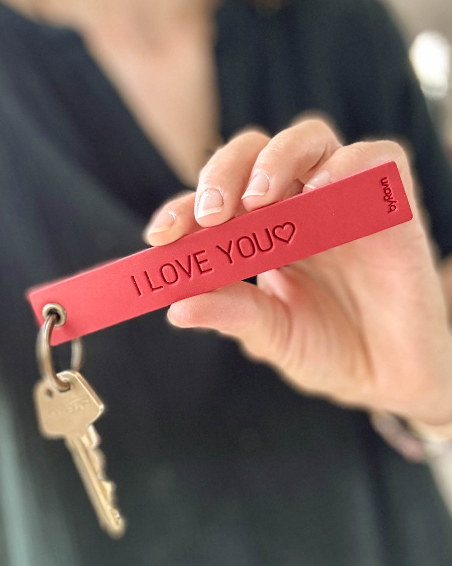 SOLO Large Schlüsselanhänger aus rotem Leder, in der Hand gehalten, mit Schlüssel und der Gravur "I love you" ♡