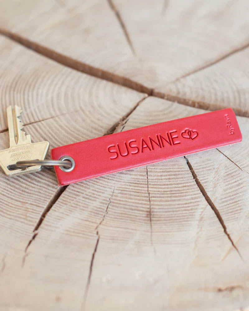 SOLO Medium Schlüsselanhänger aus rotem Leder mit dem gravierten Namen "Susanne" und zwei Herzen, mit Schlüssel auf Holzscheibe