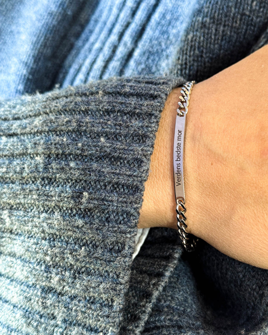 ZOE Armband aus silberfarbenem Edelstahl mit der Gravur "Verdens bedste mor" am Handgelenk, blauer Strick